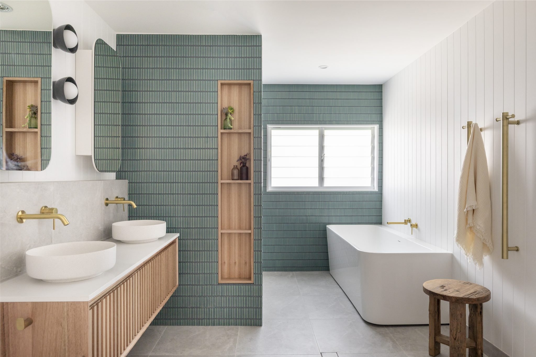 Modern bathroom with custom timber vanity in Tasmanian Oak, freestanding tub, green kitkat tile, timber niche and brass fixtures by Just in Place Sydney