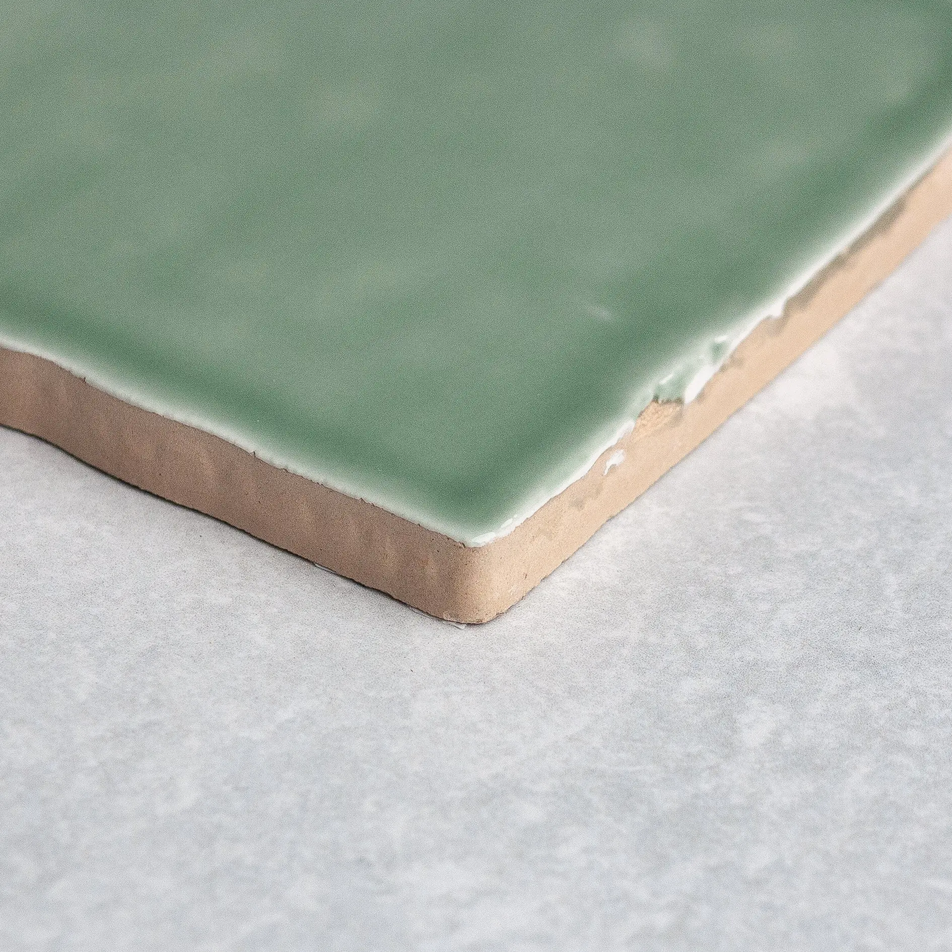 Close-up of a Lauren Sage gloss tile edge showing the handmade glaze and clay body