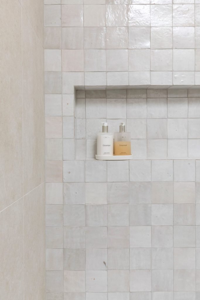 White Moroccan zellige tiles in a shower with a recessed niche
